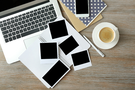 Photos and open laptop on wooden backgroundの写真素材