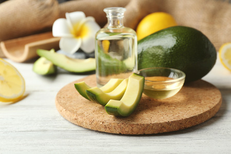Still life with avocado oil on wooden table closeup