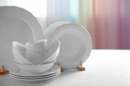 Set of new white dishes on wooden table, indoors