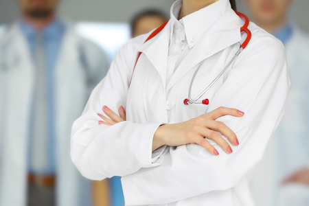 A female doctor standing in front of the colleagues, close-upの写真素材
