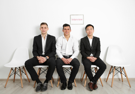 Three men waiting for interview indoors