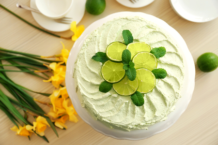 Lime cake and bouquet of yellow daffodils.の写真素材