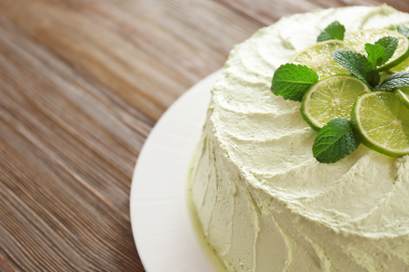 Delicious creamy lime cake on wooden table closeupの写真素材