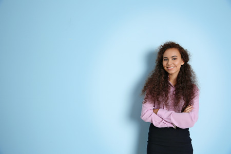 Portrait of young businesswoman against blue wall backgroundの写真素材