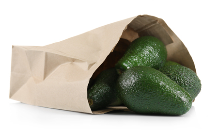 Fresh avocados in paper bag isolated on whiteの写真素材