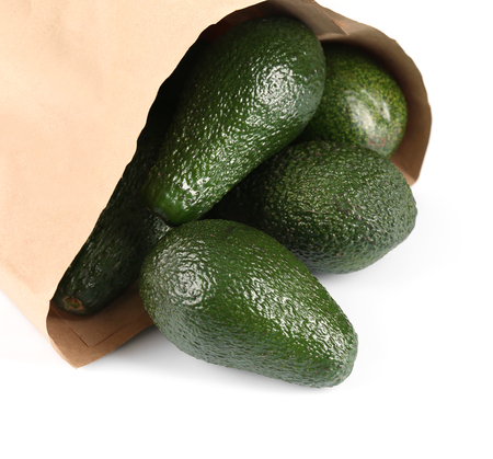 Fresh avocados in paper bag isolated on whiteの写真素材
