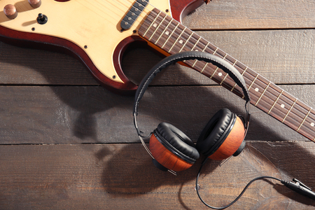 Guitar and headphones on wooden backgroundの写真素材