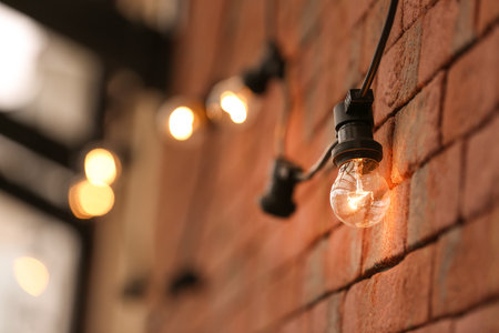 Lamp garland on brick wall background, closeupの写真素材