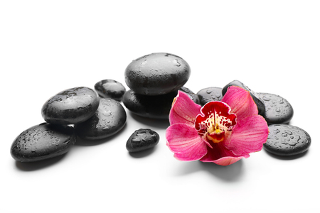 Spa stones and red orchid isolated on whiteの写真素材