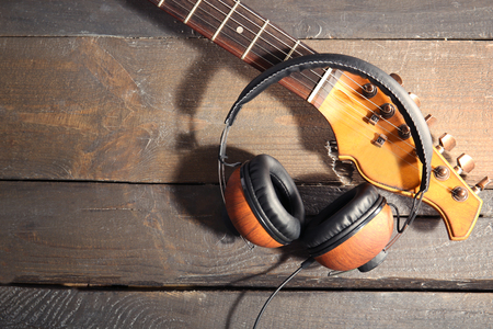Guitar and headphones on wooden backgroundの写真素材