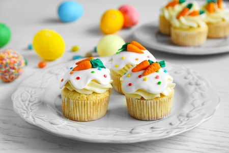 Plate with Easter cupcakes and eggs on wooden tableの写真素材