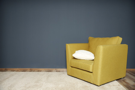 Green armchair on dark grey wall background