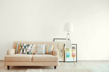 Beige couch and lamp on white wall backgroundの写真素材