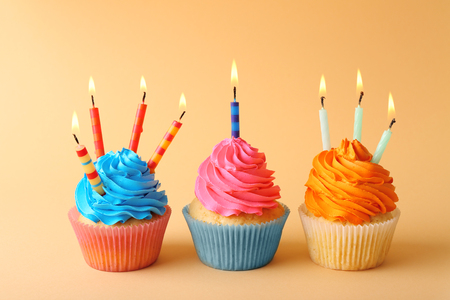 Birthday cupcakes with candles on color backgroundの写真素材