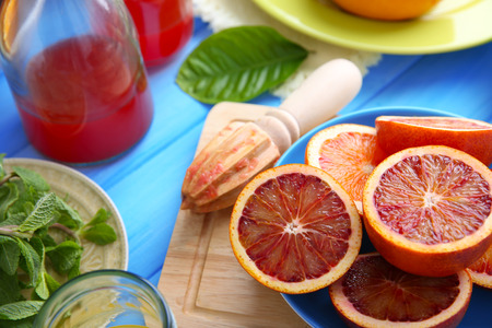 Juicing delicious citruses on blue wooden tableの写真素材