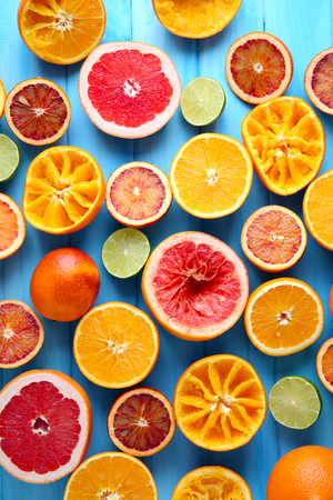 Juicing delicious citruses on blue wooden tableの写真素材