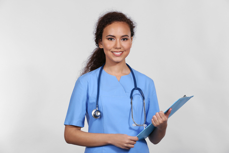 Beautiful African American female doctor on grey backgroundの写真素材