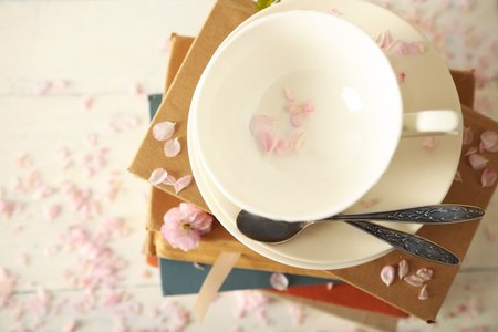 Porcelain cups with books and flowers on tableの写真素材