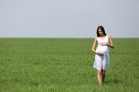 Pregnant woman relaxing in fieldの写真素材