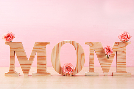 Holiday decoration with flowers and word on pink backgroundの写真素材
