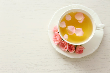 Cup of tea with roses on wooden backgroundの写真素材