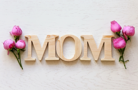 Mom word with fresh flowers on wooden background. Mother Day conceptの写真素材