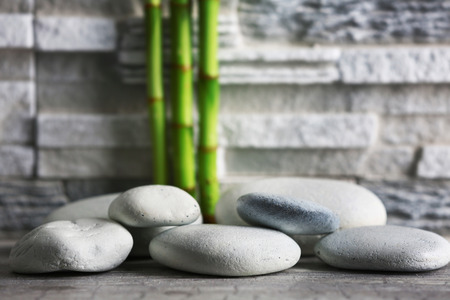 Composition of spa pebbles and bamboo on grey wall backgroundの写真素材