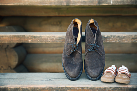 Father's shoes close to child's shoes on wooden stepsの写真素材