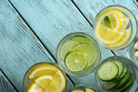 Fresh cocktails with soda, lime, lemon and cucumber on a wooden backgroundの写真素材