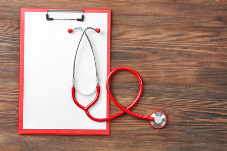 Red stethoscope with prescription on wooden backgroundの写真素材