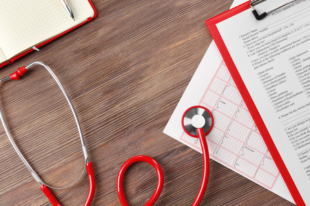 Red stethoscope with prescription on wooden backgroundの写真素材