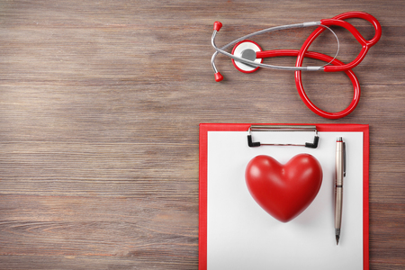 Red stethoscope with prescription on wooden backgroundの写真素材