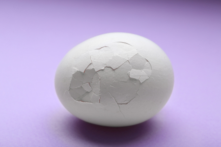 Cracked egg on purple backgroundの写真素材
