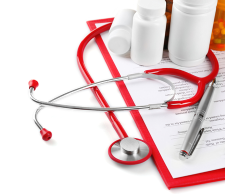 Red stethoscope and pills on white backgroundの写真素材