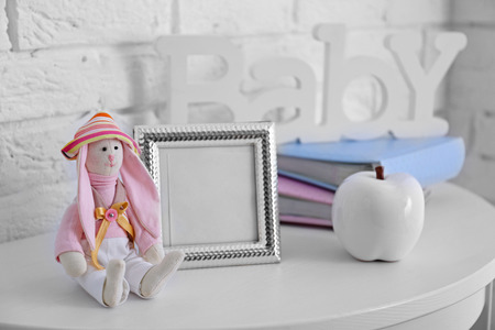 Toy rabbit with frame on white wall backgroundの写真素材