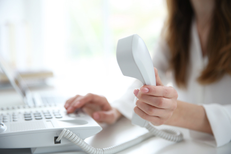 Businesswoman with office IP telephoneの写真素材