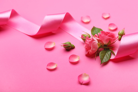 Fresh roses with ribbon on pink backgroundの写真素材