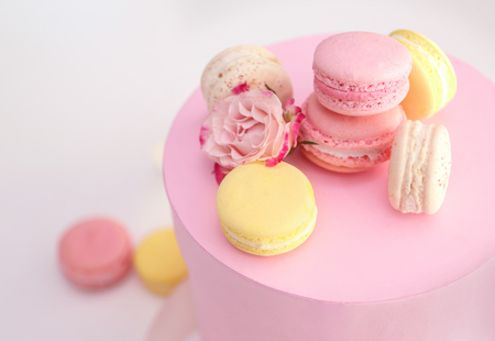 Tasty macaroons and rose in box on light backgroundの写真素材