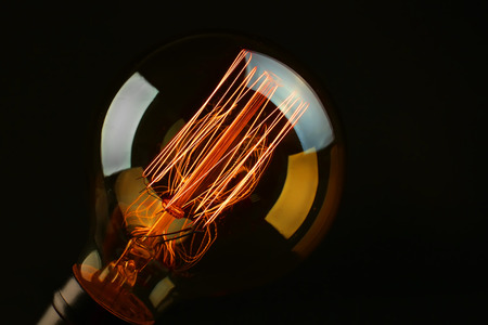 Illuminated light bulb on black backgroundの写真素材