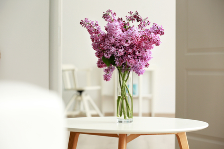 Bouquet of purple lilac flowers on white wooden tableの写真素材