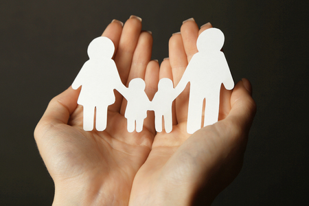 Woman hands holding wooden family shape. Love and relationships conceptの写真素材