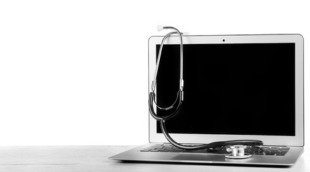 Stethoscope on laptop, isolated on whiteの写真素材