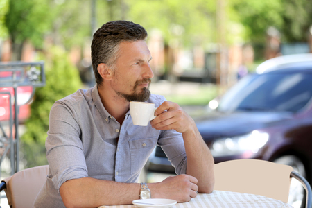 Businessman with cup of coffee relaxing in cafeの写真素材
