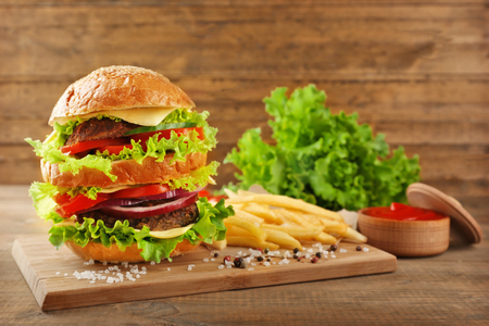 Double hamburger with fries on wooden backgroundの写真素材