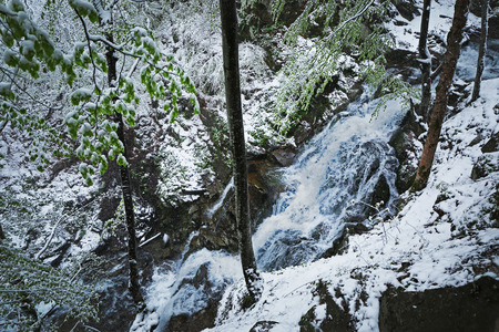 Waterfall in mountains at wintertimeの写真素材