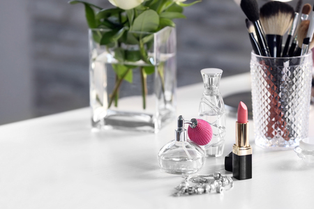 Perfume bottle with lipstick on light dressing tableの写真素材