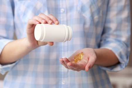 Woman taking vitamins, closeupの写真素材