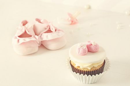 Bootees with cupcake on light backgroundの写真素材