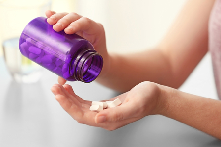 Woman taking vitamins, closeupの写真素材