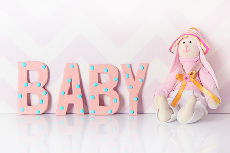 Word "Baby" with toy on light backgroundの写真素材